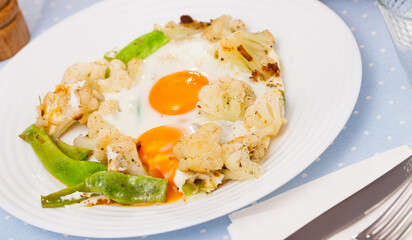 Appetizing breakfast - scrambled eggs with cauliflower and green beans