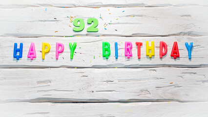 Top view of happy birthday candle numbers copy space on wooden white pastel boards. Beautiful birthday card with number 92