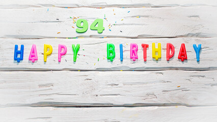 Top view of happy birthday candle numbers copy space on wooden white pastel boards. Beautiful...