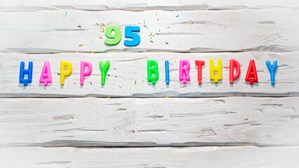 Top view of happy birthday candle numbers copy space on wooden white pastel boards. Beautiful...