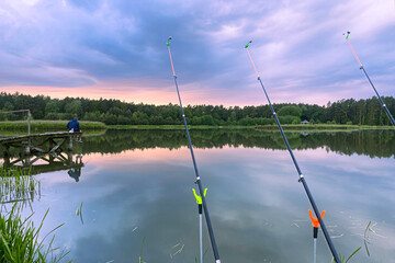 Many fishing rods stand by the lake, summer fishing