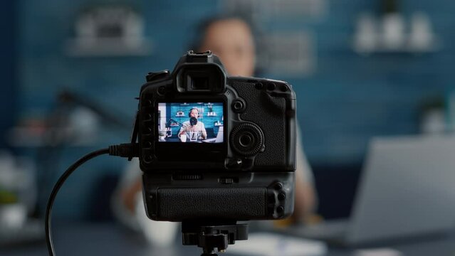 Modern Camera Filming Influencer Talking To Audience. Popular Social Media Content Creator Recording Vlog For Internet Video Sharing Platforms While Sitting At Studio Desk. Close Up