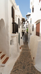between streets of white facades in the fishing village, Menorca. - 520912209