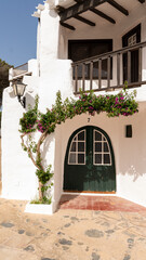 between streets of white facades in the fishing village, Menorca. - 520912221