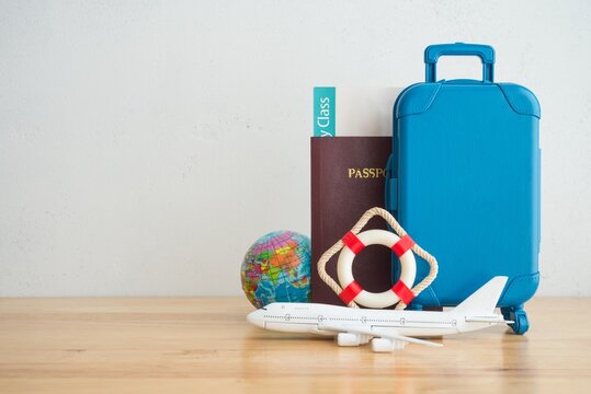 Lifebuoy safe suitcase travelers, passport, flight tickets, airplane and globe on blue background. Travel insurance covers loss suitcase, flight delays, cancellations, accident and medical expenses.