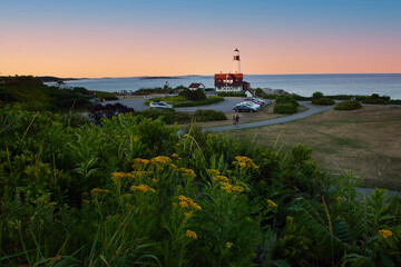 Fototapeta na wymiar Coast of the ocean with a view of the lighthouse. Maine's famous lighthouse at sunset. USA. Maine. portland head lighthouse 