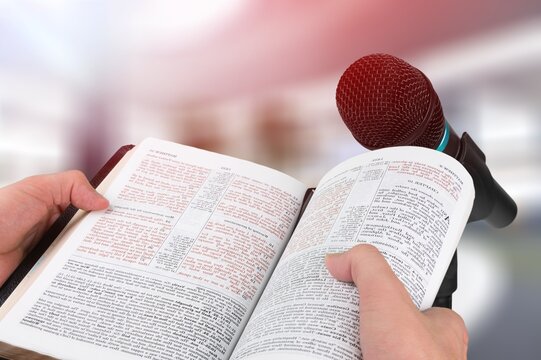 Pastor with a Bible in hand during a sermon. The preacher delivers a speech