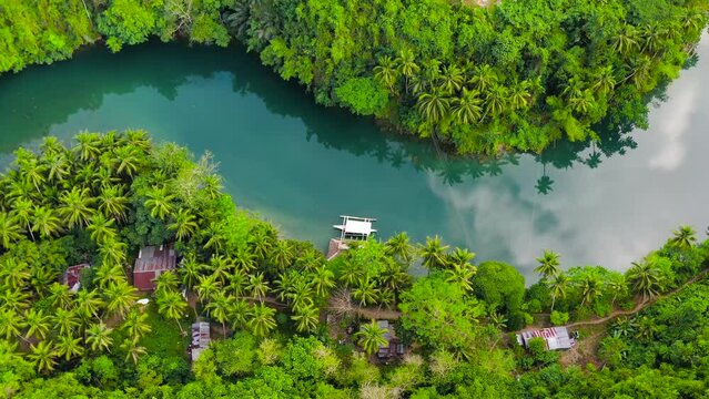 Aerial drone of Tropical Loboc river in the rainforest. Mountain river flows through green forest. Bohol, Philippines.