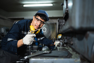 Engineer mechanical in safety suits working with grinding machine metal in the factory, Technician maintenance and check machinery, manufacturing steel industry.