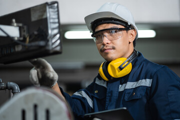 Fototapeta premium Engineer mechanical in safety suits using digital tablet working with grinding machine metal in the factory, Technician maintenance and check machinery, manufacturing steel industry.