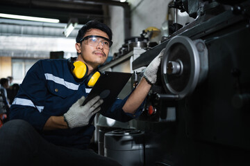 Engineer mechanical in safety suits using digital tablet working with grinding machine metal in the factory, Technician maintenance and check machinery, manufacturing steel industry.