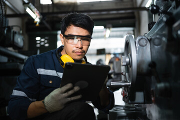 Engineer mechanical in safety suits using digital tablet working with grinding machine metal in the...