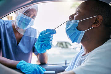 Doctor or nurse doing covid or corona virus test at a drive thru on a man sitting in a car. Medical...