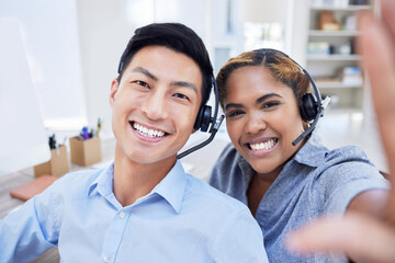 Selfie of diverse call center agents or colleagues having fun together at the office. Male and female customer service coworkers take a picture or a photo smiling in the workplace