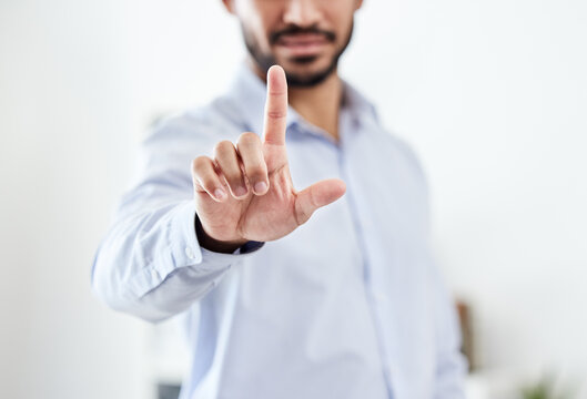 Modern, future and futuristic business man pointing his finger up pressing an empty virtual touchscreen. Closeup portrait of a corporate professional male touching an invisible screen or in an office