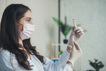 Female doctor preparing a dose of vaccine for a patient, in the hospital. Coronavirus vaccination. Pandemic prevention. Virus, epidemic, disease.
