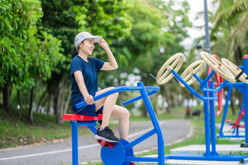 Asian woman exercising riding on spinning bike at the outdoor park.