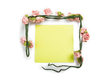 Empty yellow notes with a frame of pink rose flowers stem