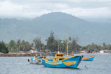 three fishing boats that are neatly parked in the sea