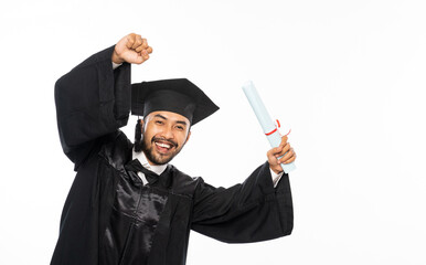 Excited male college graduate student wearing toga holding roll certificate standing on isolated...