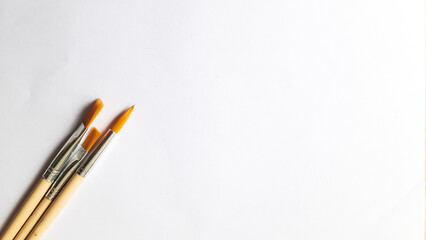 Top view of a variety of artist brushes on a white background with room for text. Creative postcard