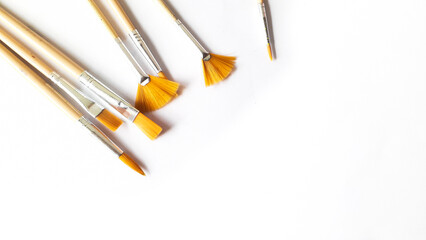 Top view of a variety of artist brushes on a white background with room for text. Creative postcard