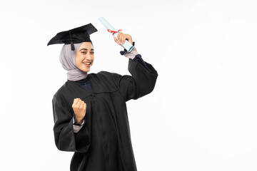 Female bachelor graduate wearing toga with hand clenched while holding a roll of diploma paper...