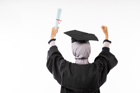 Rear behind view photo of female college graduate wearing toga holding a certificate standing on isolated background