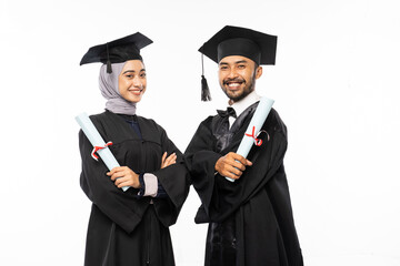 Two asian graduate students wearing togas with crossed arms while holding certificate on isolated background