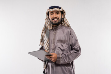 portrait of asian male with turban using a tablet against a plain white background