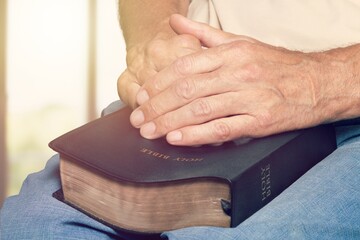 The Bible is in hand, praying with religious faith and belief in god on blessing background The power of hope or love and devotion.