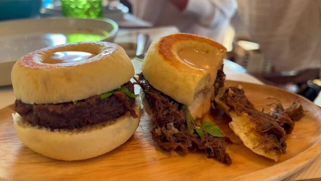 Eating traditional Spanish brioche buns with oxtail starter in Bibo Beach House Tarifa restaurant, famous tapas in restaurant of Dani Garcia in Spain, 4K shot