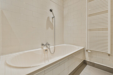 Interior of modern bathroom with bathtub and sink in wooden counter furnished with wooden shelf rack