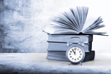 Black and white still life with old books and alarm clock
