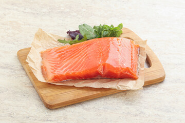 Raw salmon fillet over board