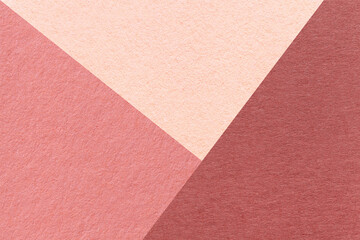 Texture of craft red, pink and coral shade color paper background, macro. Structure of vintage abstract rose cardboard with geometric shape and gradient. Felt maroon backdrop closeup.