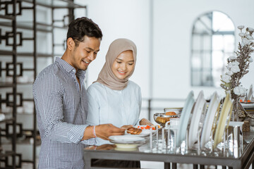 Young asian couple looking at choosing ceramic plates in houseware store