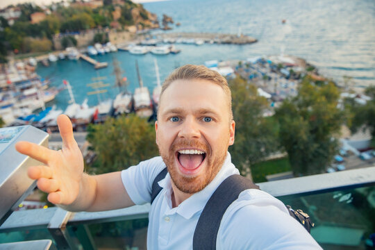 Man tourist take selfie photo background Kaleici Antalya old town port, Mediterranean Sea, Turkey
