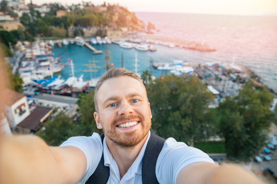 Man tourist take selfie photo background Kaleici Antalya old town port, Mediterranean Sea, Turkey sunlight