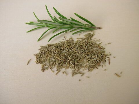 Dried and chopped rosemary on a wooden board