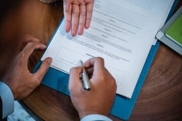 close up of businessman signing an agreement letter during meeting
