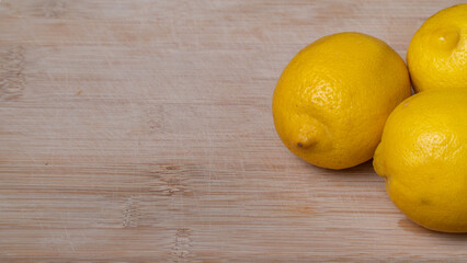 Yellow lemons on a wooden background close-up