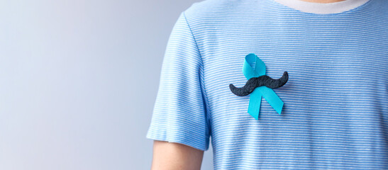 November Prostate Cancer Awareness month, Blue Ribbon with mustache for supporting people living...