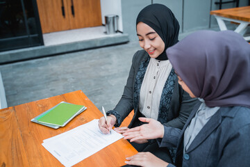 portrait of muslim businesswoman signing an agreement letter during meeting with partner