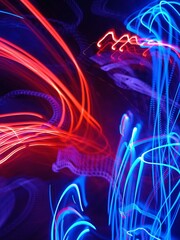 Blue and red light painting photography, long exposure fairy blue and red lights curves and waves against a black background. Abstract motion curvy urban road with neon light motion effect applied .
