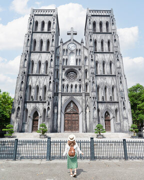 Woman traveller is sightseeing at St Joseph's Cathedral (Nha Tho Lon in Vietnamese) in Hanoi, Vietnam