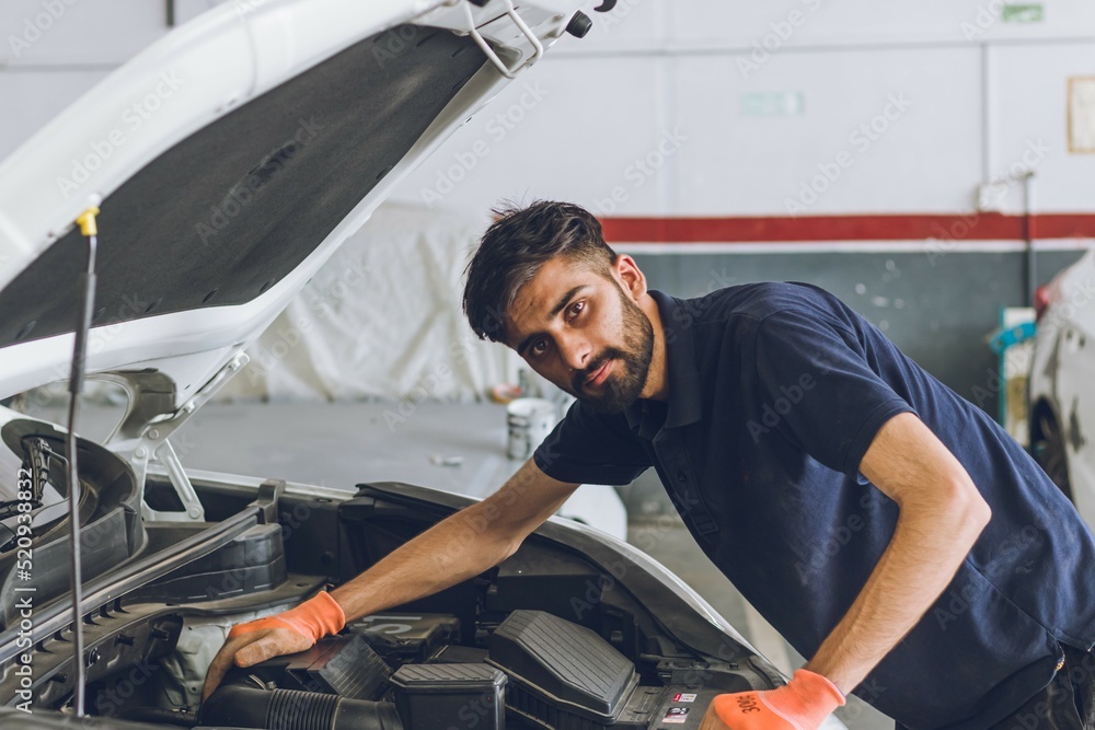 Wall mural pakistani or indian mechanic repairing a car in garage