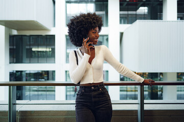 Fototapeta na wymiar Black afro woman talking on mobile phone in the city