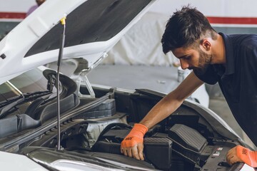 Pakistani or Indian Mechanic repairing a car in garage