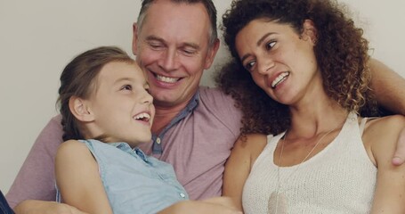 Excited, laughing and play during family bonding in home living room. Mother, father and daughter talking, having fun and enjoying weekend. Parents teasing, joking and tickling adorable, cute child